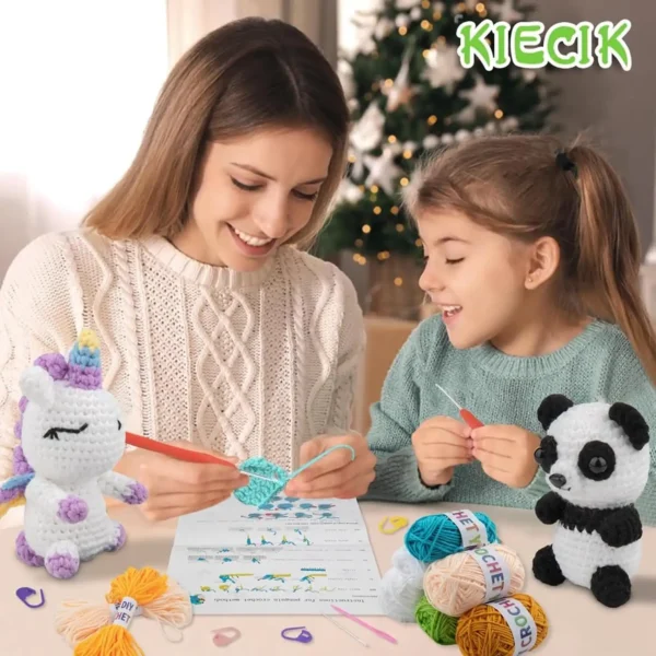 Mother and daughter crocheting together at a table, surrounded by colorful yarn and completed unicorn and panda amigurumi plushies.