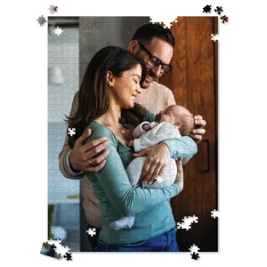 Completed large custom photo puzzle of parents lovingly holding their newborn baby, with some pieces still being assembled.