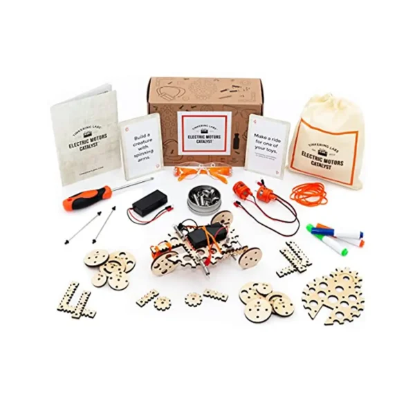 Electric Motors Catalyst kit contents displayed with idea cards, instruction manual, tools, and a built motorized car in front of the packaging.