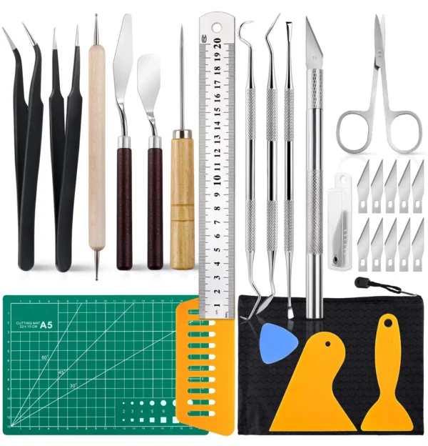 Assorted sculpting tools and accessories including knives, rulers, tweezers, and cutting mat arranged neatly.