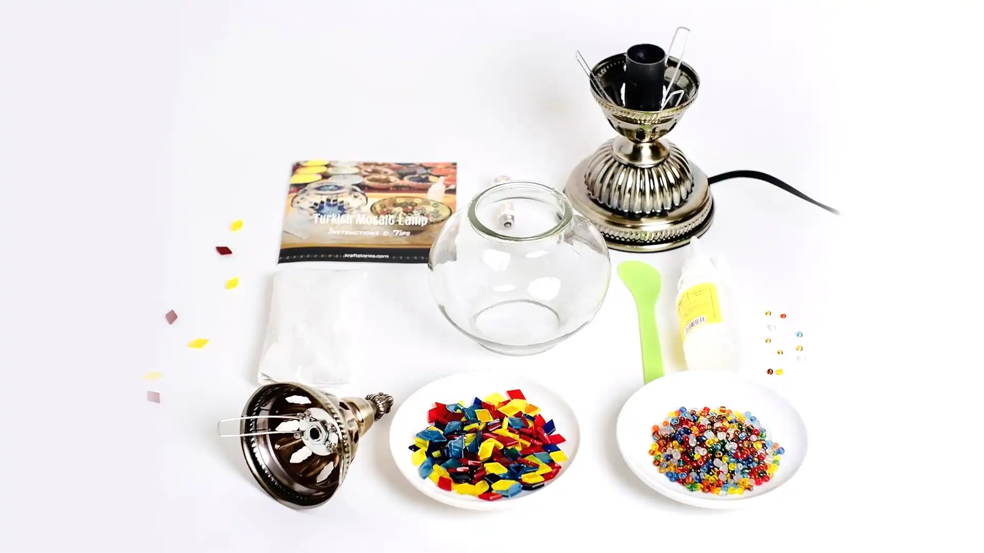 Turkish Mosaic Lamp Kit DIY Glass 3 A Turkish mosaic lamp kit with a bronze base, colorful glass tiles, beads, glue, and instructions laid out on a workspace — designed for hands-on DIY assembly.